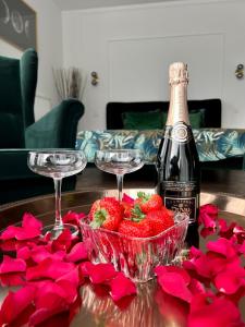 ArsimontCoeur Nature的一张桌子,上面放有两杯酒杯、草莓和红玫瑰