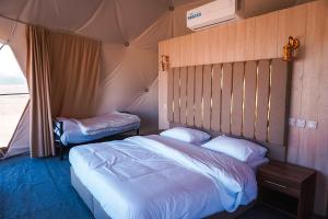 瓦迪拉姆Mirage Camp Wadi Rum的一间帐篷内带两张床的卧室