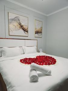 阿拉木图PERFECT APARTMENTS的一张床上有一大堆红玫瑰