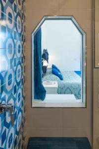 波西塔诺佛罗里达住宿酒店的镜子在浴室里,在房间内有床