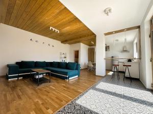 SohodolCasa Aluna Duo的一间带蓝色沙发的客厅和一间厨房