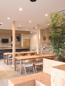 高崎Matoi Hostel & Bar的用餐室配有木桌和椅子