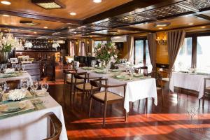 下龙湾Hera Cruises Group on Ha Long Bay的一间设有白色桌椅的用餐室