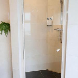 Appeltern默尔克莫伦酒店的带淋浴的浴室,带玻璃门