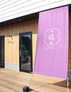 高崎Matoi Hostel & Bar的建筑前的紫色窗帘