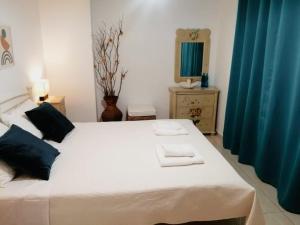StamatopoulaíikaLakkopetra Sunrise的卧室配有一张带蓝色窗帘的大型白色床