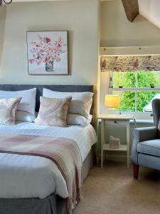 埃格顿Broom House at Egton Bridge的卧室配有床、椅子和窗户。