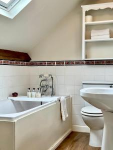 埃格顿Broom House at Egton Bridge的白色的浴室设有浴缸和卫生间。