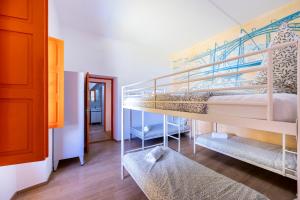 拉戈斯The Macarena Beach Hostel的带两张双层床的客房和走廊