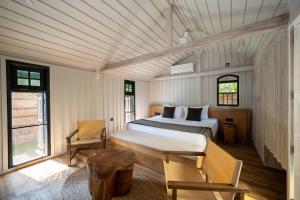 KamburugamuwaOcean front cabin in Madiha的一间卧室配有一张床和一把椅子