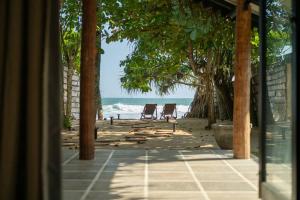 KamburugamuwaOcean front cabin in Madiha的享有海滩和大海的美景,配有两把椅子