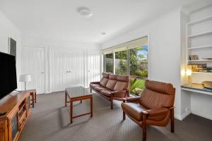 托基Stunning ocean views indoor spa and sun deck的客厅配有2把椅子和平面电视
