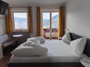 拉古多Plarserhof的卧室配有一张白色大床和两个窗户