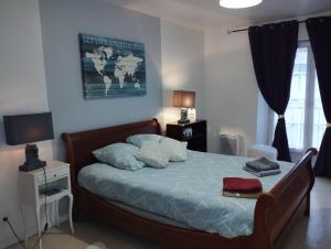 迪耶普L'Écluse的一间卧室配有一张带蓝色床单和枕头的床。