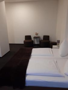 柏林博尔豪斯柏林旅舍的一间卧室配有一张带两把椅子和一张桌子的床。
