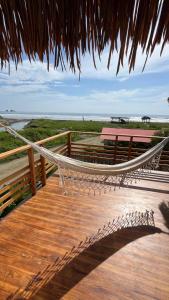 Las TunasVillas del Mar的海滩上带吊床的木甲板