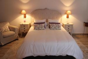 贝尔蒙特La Casa de la Vieja - Alojamiento Rural 3 y 4 Estrellas的卧室配有带枕头和椅子的白色床