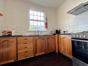 霍巴特Hobart City Oasis with 3 beds的一个带木制橱柜和窗户的大厨房