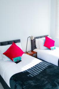 伦敦Stunning-Gated-Listed Stay-Park-Homestay-Retreat的两张彼此相邻的床,配有红色枕头