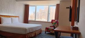 高雄逸亭商旅 的酒店的客房 - 带一张床、椅子和窗户