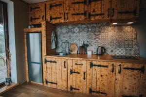 PāleBrīvdienu māja Straumēni的厨房配有木制橱柜和瓷砖墙。