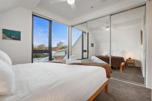 墨尔本Green getaway 1 Bedder Loft@ St kilda with parking的一间卧室设有一张大床和一个大窗户