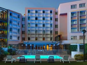 马赛宜必思马赛伯尼维尼卡兰奎斯勒斯普利兹酒店的一座酒店,在一些建筑前设有一个游泳池