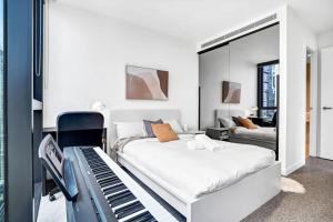墨尔本Collins House - Melbourne Cbd Amazing view的一间卧室配有一张床和一架钢琴