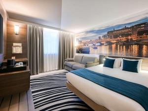 巴黎巴黎中心贝西诺富特酒店的酒店客房设有一张大床和一张沙发。