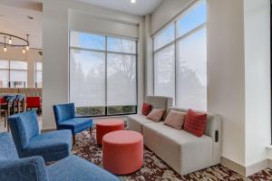 印第安纳波利斯西北印第安纳波利斯希尔顿花园酒店的客厅配有蓝色和红色的椅子和沙发