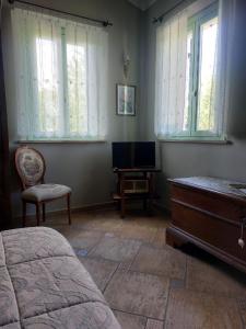 切塞纳蒂科Locanda Antico Casale Cesenatico的一间卧室配有一张床、梳妆台和电视。