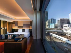 东京Pullman Tokyo Tamachi的酒店客房设有一张床和一个大窗户