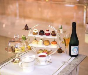 迪拜Kempinski Hotel Mall of the Emirates, Dubai的一张桌子,上面放着一盘糕点和一瓶葡萄酒