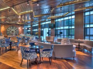 雪邦吉隆坡国际机场瑞享酒店及会议中心的餐厅设有桌椅和窗户。