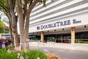休斯顿DoubleTree by Hilton Houston Medical Center Hotel & Suites的上面有高标的建筑