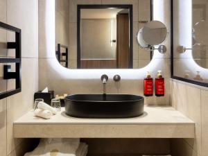 里昂Pullman Lyon的浴室设有黑色水槽和镜子