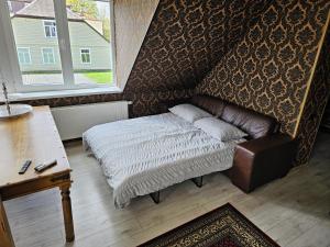 罗基什基斯Square apartments的一间卧室配有一张床、一张桌子和一个窗户。