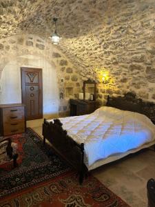 马尔丁Rumet paşa konağı的一间卧室设有一张床和石墙