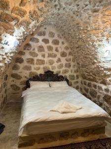 马尔丁Rumet paşa konağı的卧室配有一张石墙床