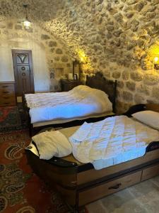马尔丁Rumet paşa konağı的一间卧室设有两张床和石墙