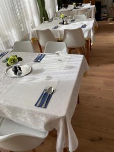 勒沃库森Haven - Hotel Am Stadion的一组桌子,配有白色的桌椅