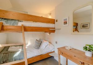 布莱克尼Parsley Cottage的一间卧室配有两张双层床和镜子