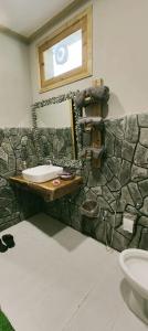 吉尔吉特Das-e-Basi的石质浴室设有水槽和镜子