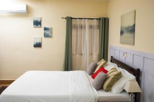 洛美乐佩里堪酒店的一间卧室配有带白色床单和枕头的床。