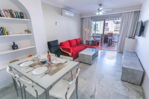 内尔哈Los Huertos de Nerja 6的客厅配有桌子和红色沙发