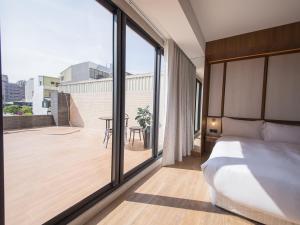 安平区安平‧留饭店的一间卧室设有一张床和一个大窗户