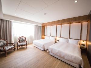 安平区安平‧留饭店的酒店客房,配有两张床和椅子