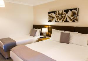 纽基彭迪尔酒店的酒店客房设有两张床,墙上挂有绘画作品