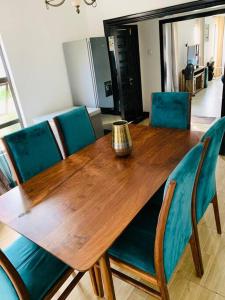 卢萨卡Perchment view Apartment的一张带蓝色椅子的木桌和花瓶