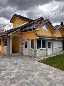拉克塔希Vikendica Leona的前面有车道的黄色房子